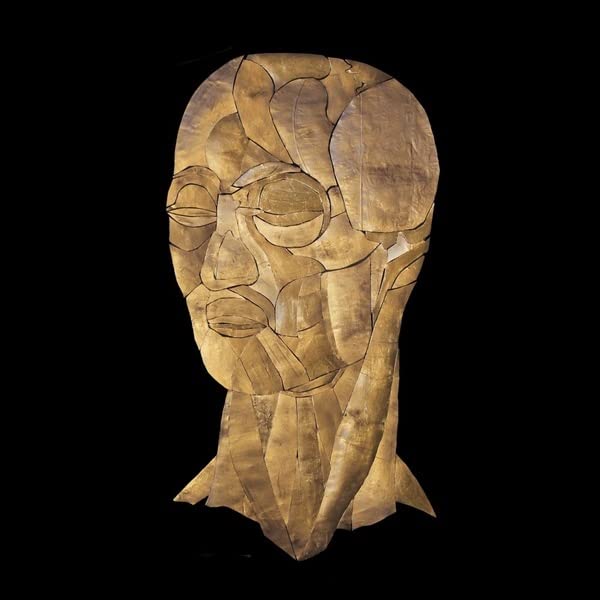 Abstract portrait of a face constructed from light brown, fragmented shapes.