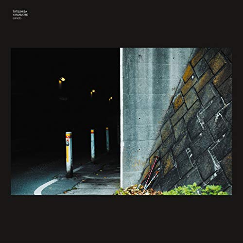 Vinyl album cover featuring a dark street scene and textured wall.