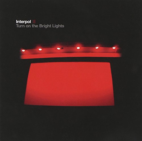 "Album cover with red lights on a black background, Interpol's 'Turn on the Bright Lights'."