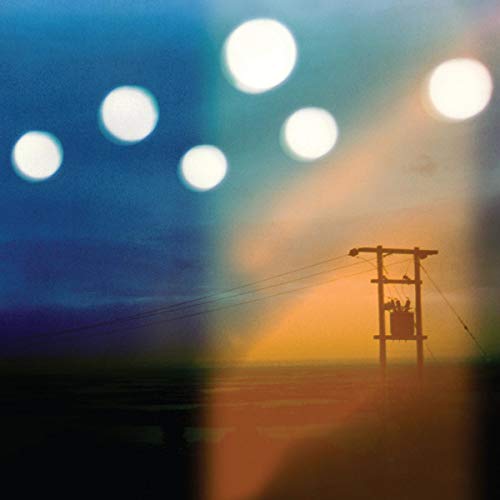 Power pole with blurred orbs against a blue and orange sky.