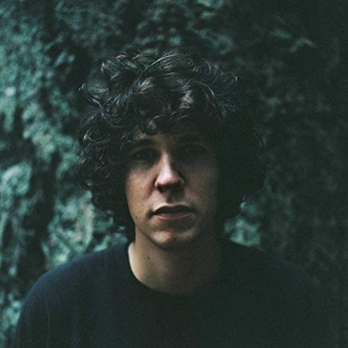 Close-up portrait of Tobias Jesso Jr. with dark, curly hair.
