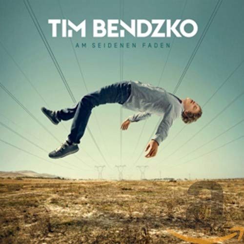 Album cover: man appearing to float above a dry, grassy field.