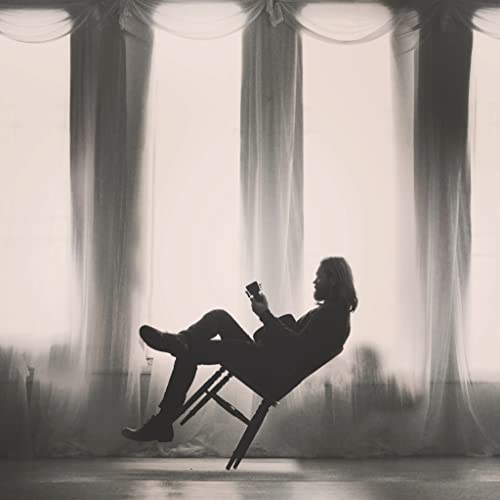 Black and white vinyl record cover featuring a silhouetted man with a guitar.