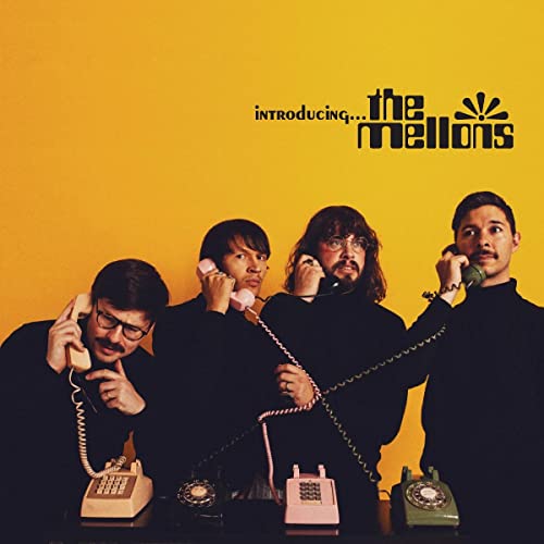 Four men with vintage telephones against a bright yellow background.