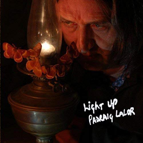 Close-up of a man’s face illuminated by a glowing oil lamp.
