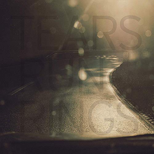 Vinyl record on a wet, reflective surface with blurred light flares.