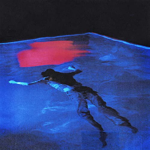 Person floating in blue water with a red shape above.