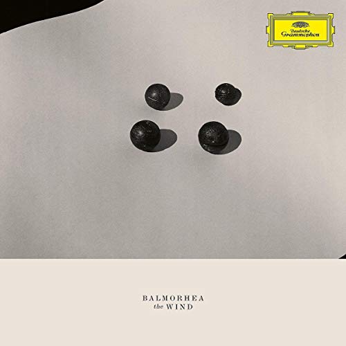 The image shows a CD cover with a minimalist design. alt text: "CD cover with four black spheres on a white background."