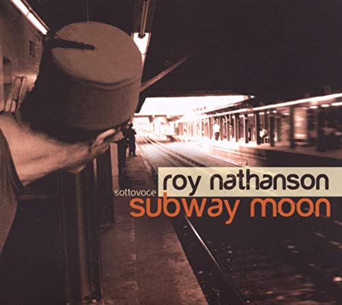 CD cover: person with hat at a dimly lit subway platform.