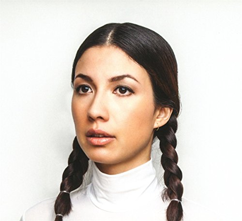 Portrait of Emmy The Great, a woman with dark braided hair.