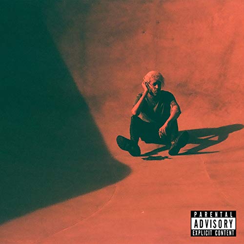 ALHLBred-toned image of a person sitting on the ground against a wall.