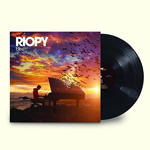 Vinyl record with cover art of a person playing piano at sunset.