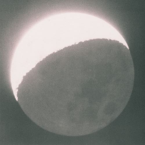 Half moon illuminated by earthlight, grainy black and white photograph.