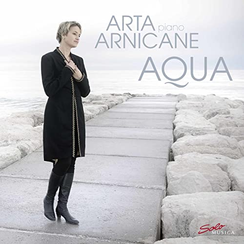 CD cover: Woman in coat stands on a stone jetty by the sea.