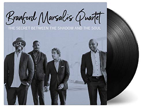 Black and white image of four men in suits on a vinyl album cover.