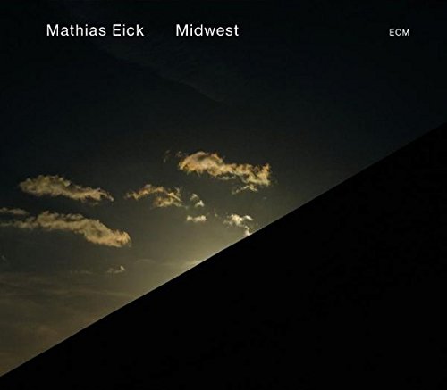 "Album cover with dark sky, clouds, and diagonal shadow, featuring 'Mathias Eick Midwest' text."