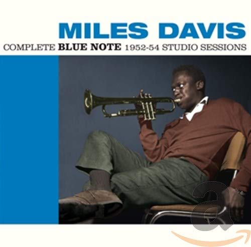 Miles Davis album cover: man sitting, holding trumpet, blue and white background.