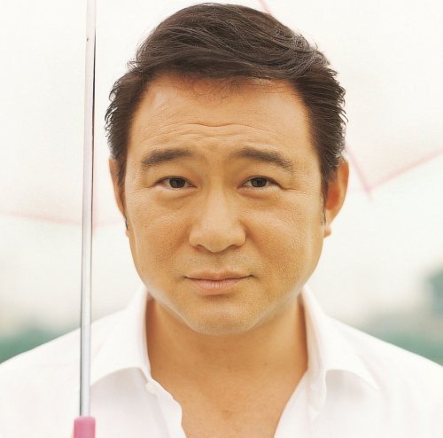Close-up portrait of a middle-aged Asian man with a white umbrella.