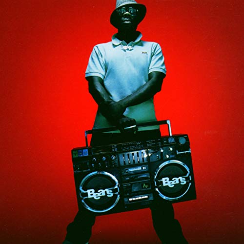 Man in a hat and polo shirt holding a boombox against a red background.