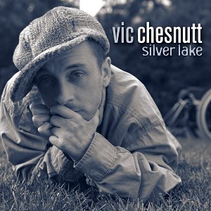 Vic Chesnutt's album cover: man in hat lying on grass with bicycle behind.