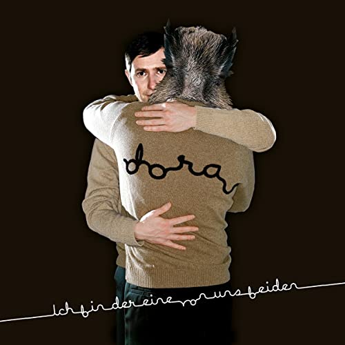 Man in sweater hugging a creature with a furry animal head.