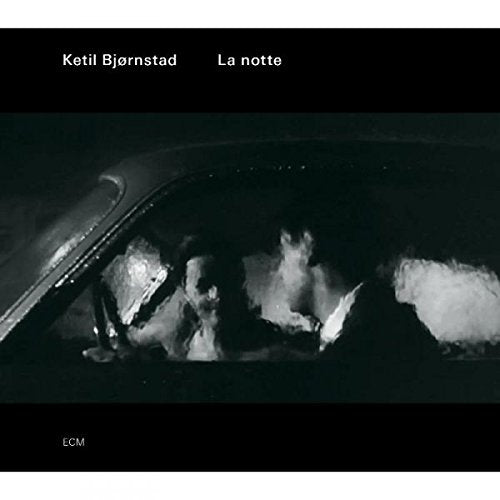 A black-and-white image of a couple in a car, with Amazon logo.