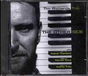 CD case with black and white image of man's face and piano keys design.