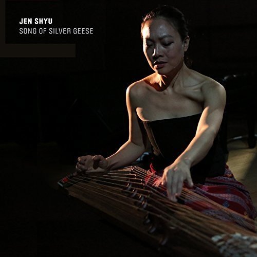 Jen Shyu album cover: woman playing a zither-like instrument, dark background, Amazon logo.