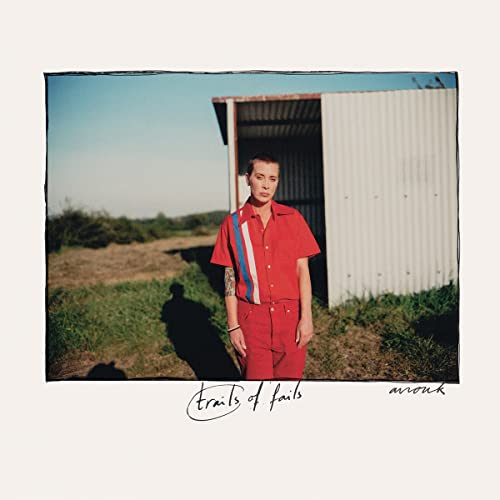 Album cover: woman in red shirt standing in front of a shed.
