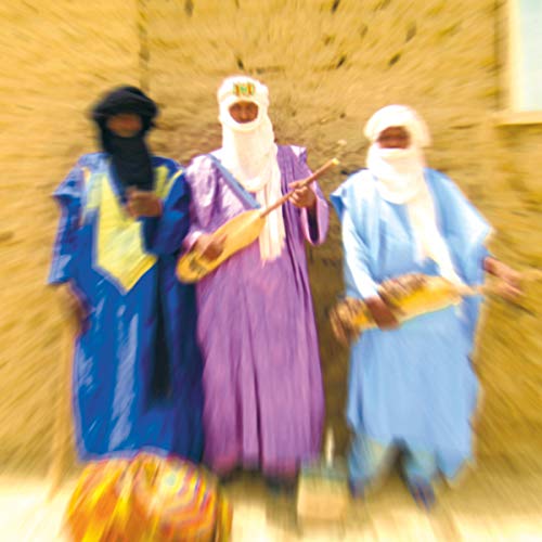 Three veiled musicians with instruments in front of a sandy wall.