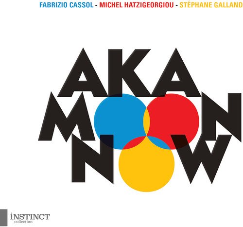 The image shows a CD cover with the title "Aka Moon - Now". Here is a possible alt text: "CD cover with 'AKA MOON NOW' in black text and colorful circles."