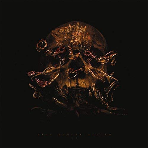Dark, ornate golden Buddha head with multiple arms against a black background.