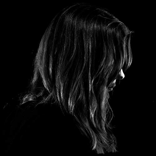The image depicts a black-and-white portrait of a woman with long hair. For accessibility purposes, a suitable alt text could be: "Black-and-white portrait of a woman with long, wavy hair."