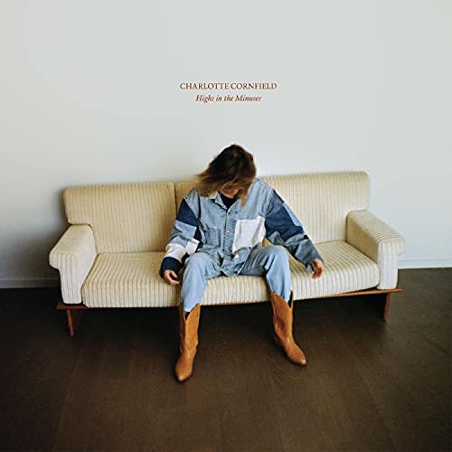 Album cover: woman in denim sits on a striped sofa.