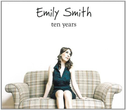 "Album cover featuring a woman in a blue dress sitting on a plaid couch."
