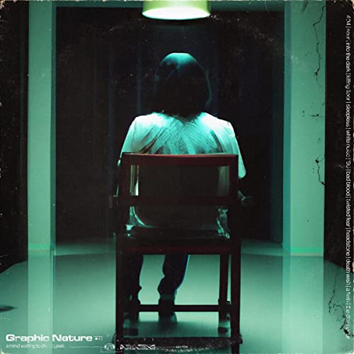 Person seated in a dark hallway, viewed from behind.