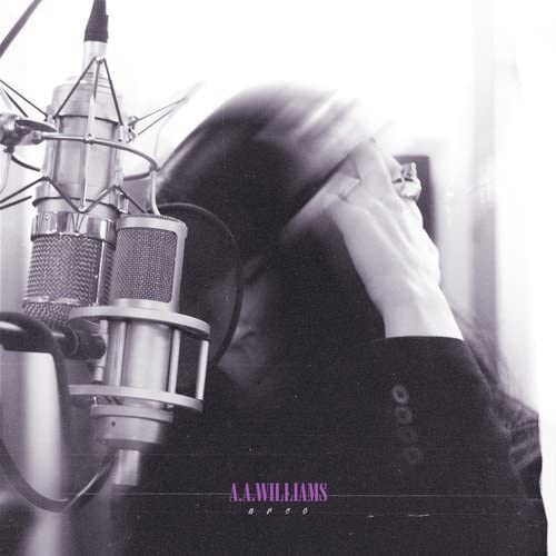 Black and white photo of a person singing into studio microphones.