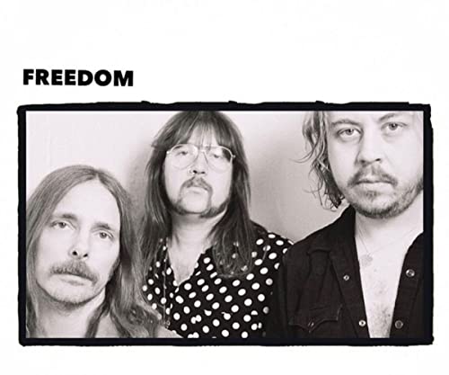 Black and white portrait of three long-haired musicians.