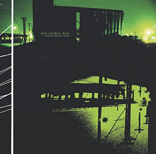 Green-toned industrial landscape with buildings, power lines, and a cross.
