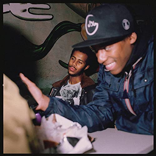 CD cover featuring two men with a graffiti-covered wall background.