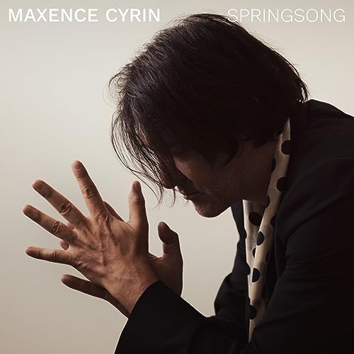 Maxence Cyrin album cover: a man with hands raised, looking down.