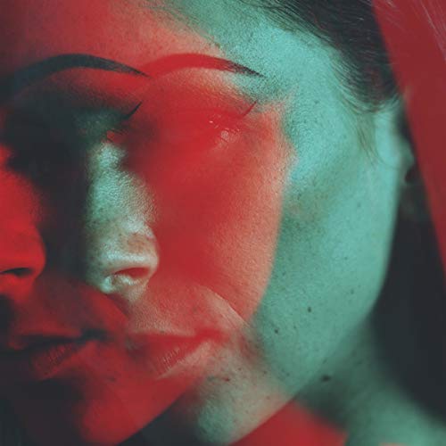 A woman's face is shown with red and green lighting.