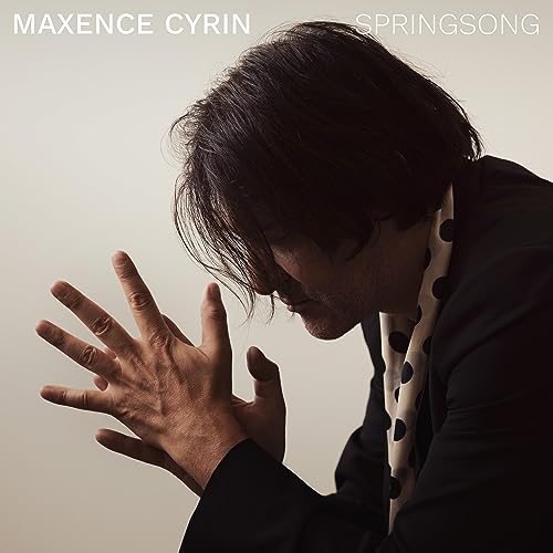 Maxence Cyrin album cover: man with hands raised, dark hair, white background.