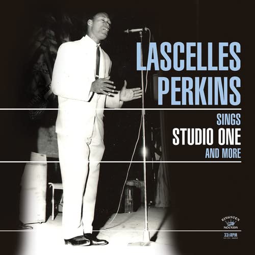 Black and white photo of Lascelles Perkins singing into a microphone on stage.