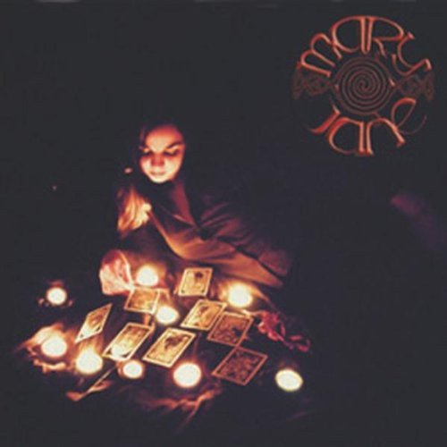 The image depicts a woman surrounded by lit candles and tarot cards. For accessibility purposes, a suitable alt text could be: "Woman crouching, surrounded by tarot cards and lit candles."