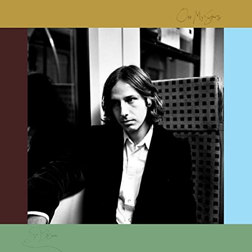 Black and white portrait of a man on public transport, album cover.