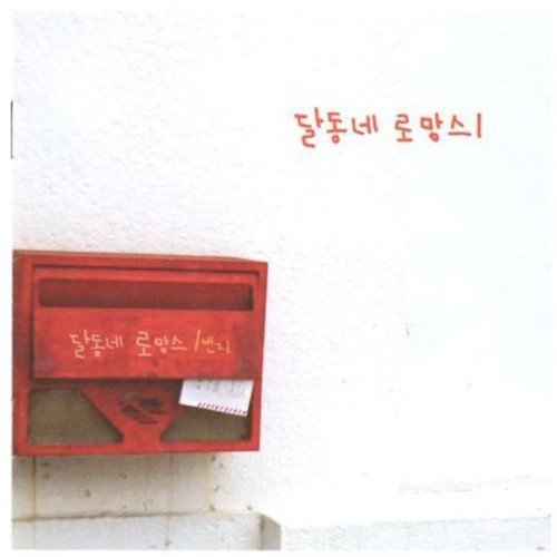Red mailbox on a white wall with Korean text above and on it.
