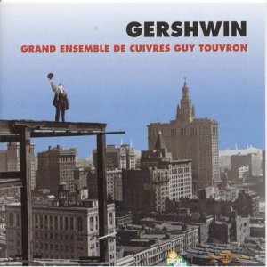 CD cover: Silhouette atop a building overlooking a city skyline.