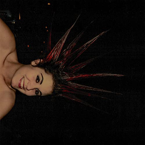 Album cover featuring a person with a dramatically styled, spiky red hairstyle.