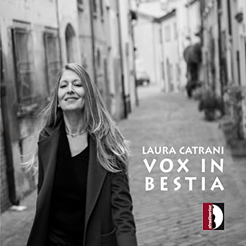 Woman with long hair and album cover "Vox In Bestia" visible.